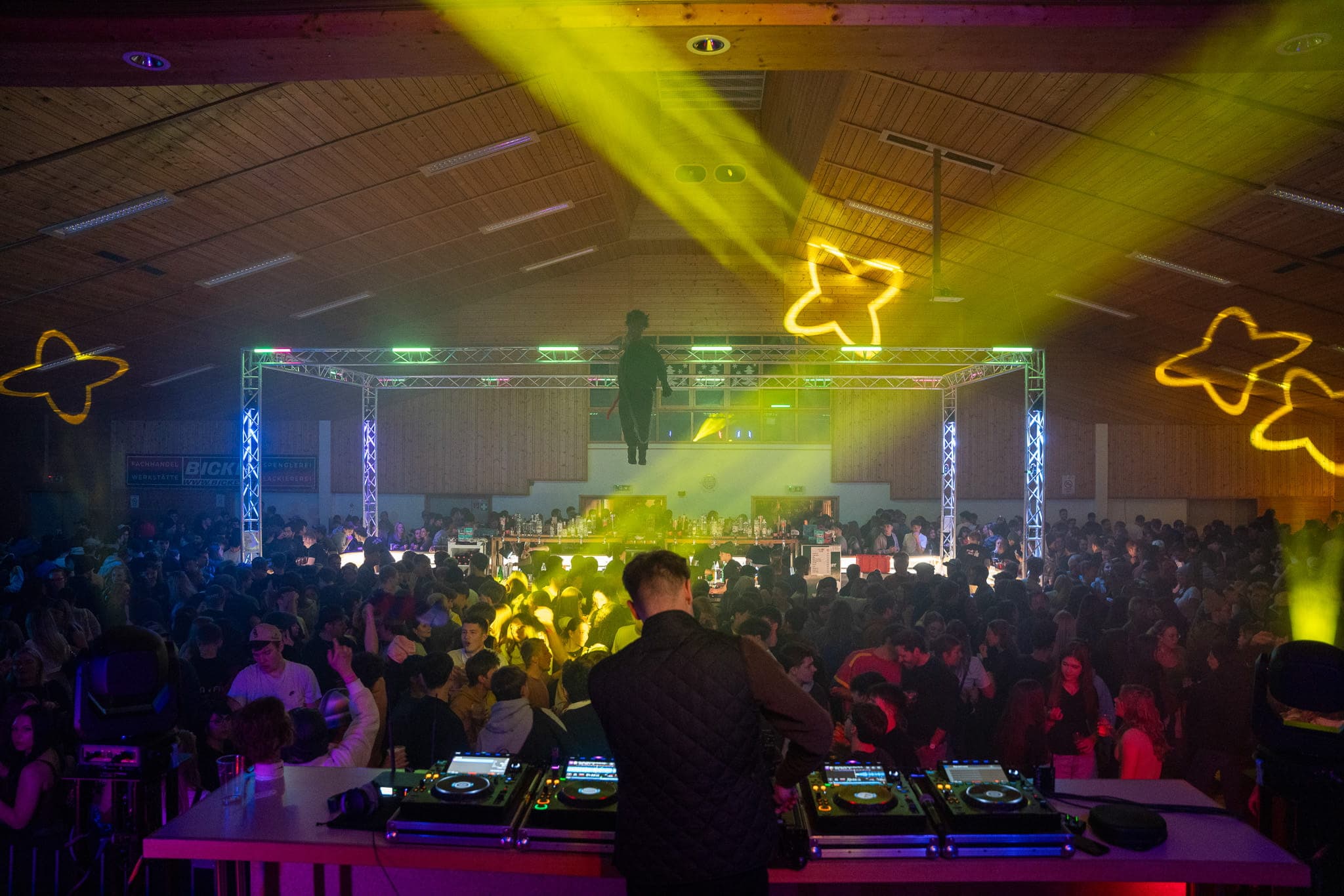 Blick vom DJ-Pult auf die volle Walserhalle im bunten Licht