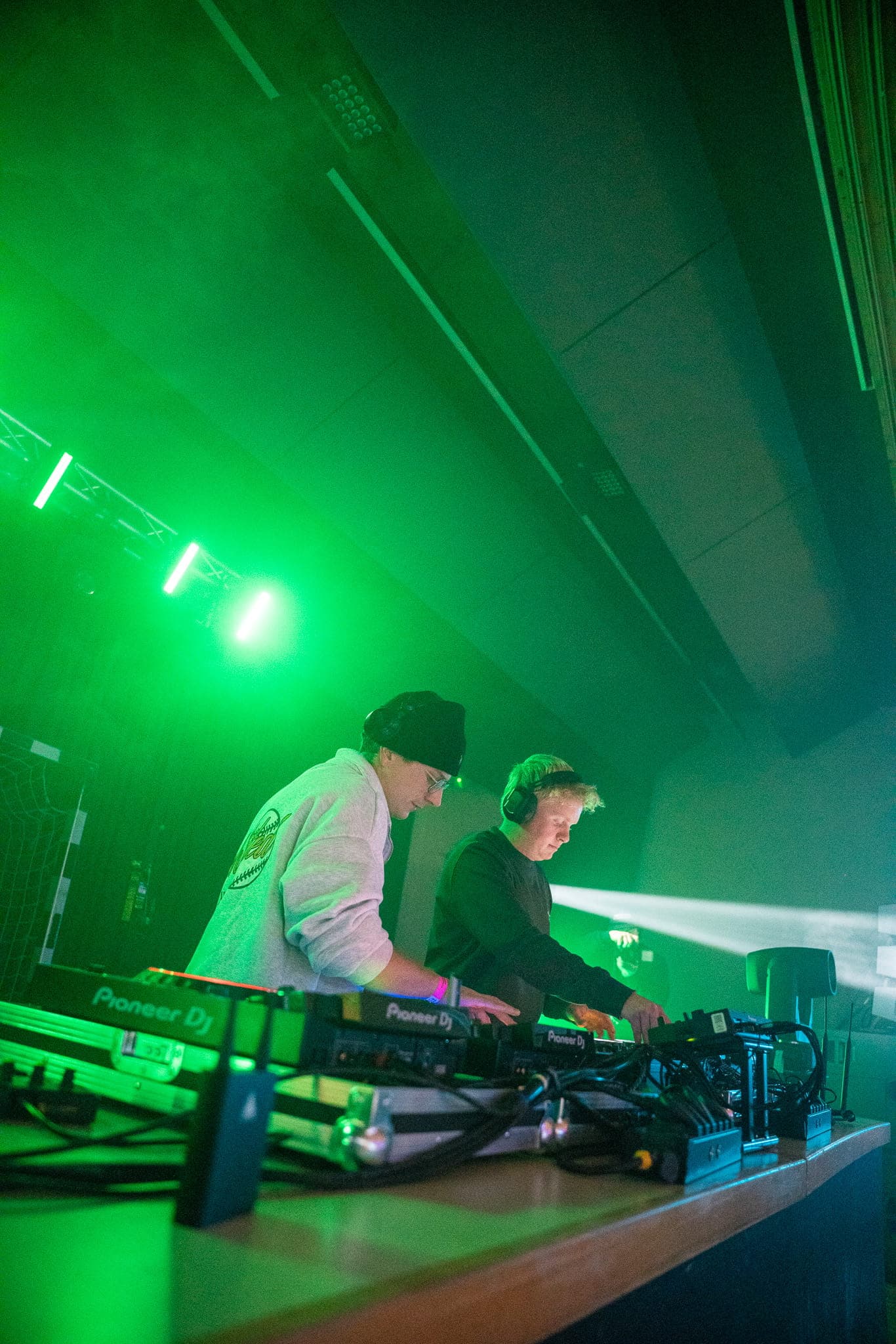 Zwei DJs legen im grünen Bühnenlicht auf